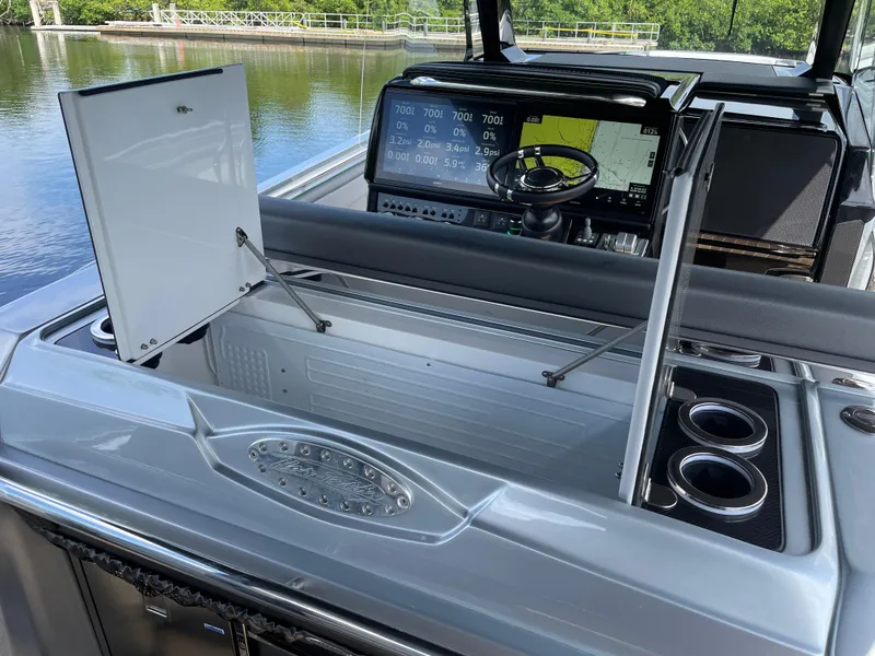 Slide: The Image of 2024 Nor-Tech 500 Sport boat dashboard with open storage and navigation display. - 42