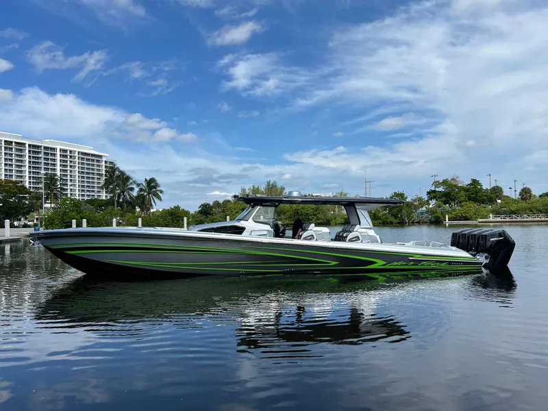 Slide: The Image of 2024 Nor-Tech 500 Sport boat on calm water, with a sleek green and black design. - 6