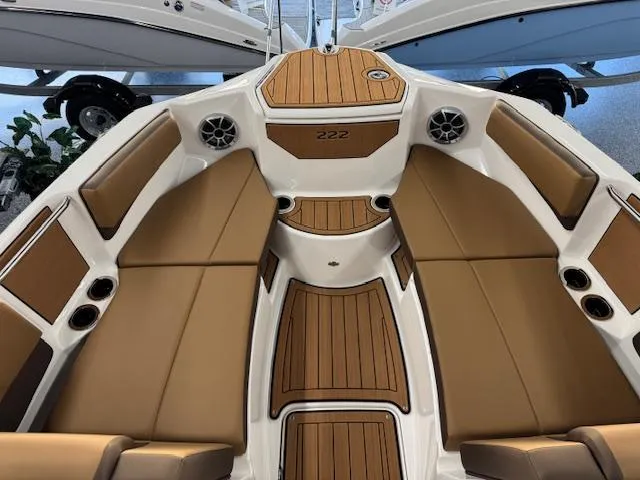 Slide: The Image of 2025 Yamaha Boats 222S interior with tan seating and wood accents, showcasing luxury design. - 2