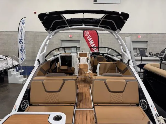 Slide: The Image of 2025 Yamaha Boats 252SE interior with tan seating and sleek design at a boat show. - 2