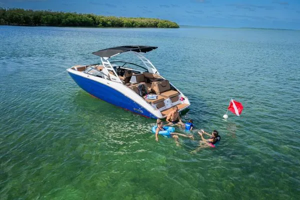 Slide: The Image of 2025 Yamaha Boats 252SE in clear water with people swimming nearby. - 22