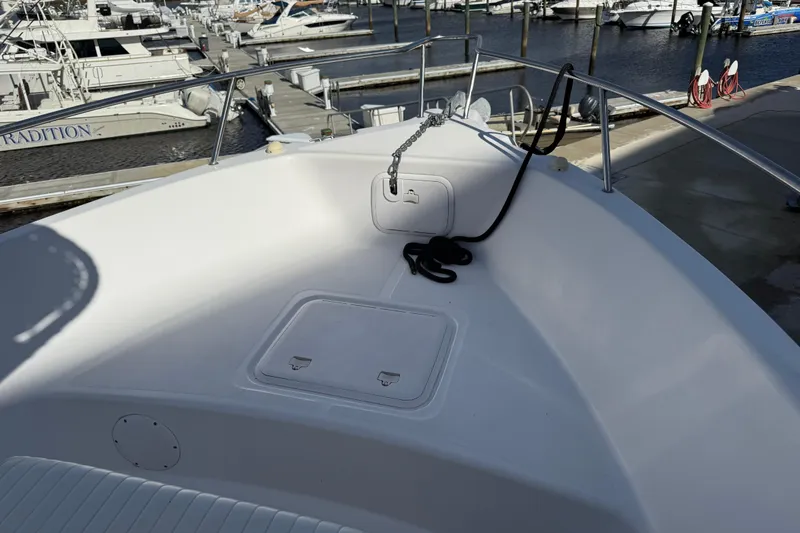 Slide: The Image of 2006 Pro-Line 21 Sport boat bow at marina, featuring anchor and rope. - 10