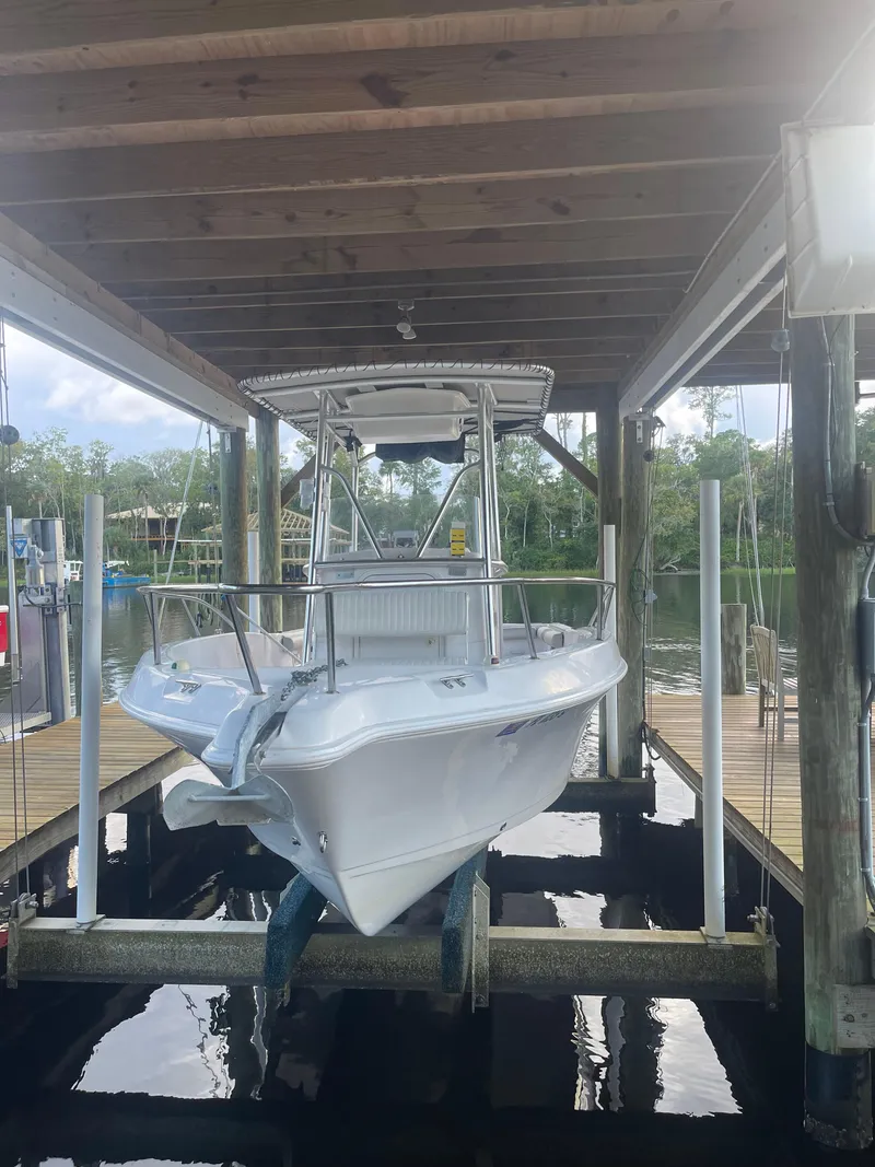 Slide: The Image of 2006 Pro-Line 21 Sport boat on lift under wooden dock shelter. - 15