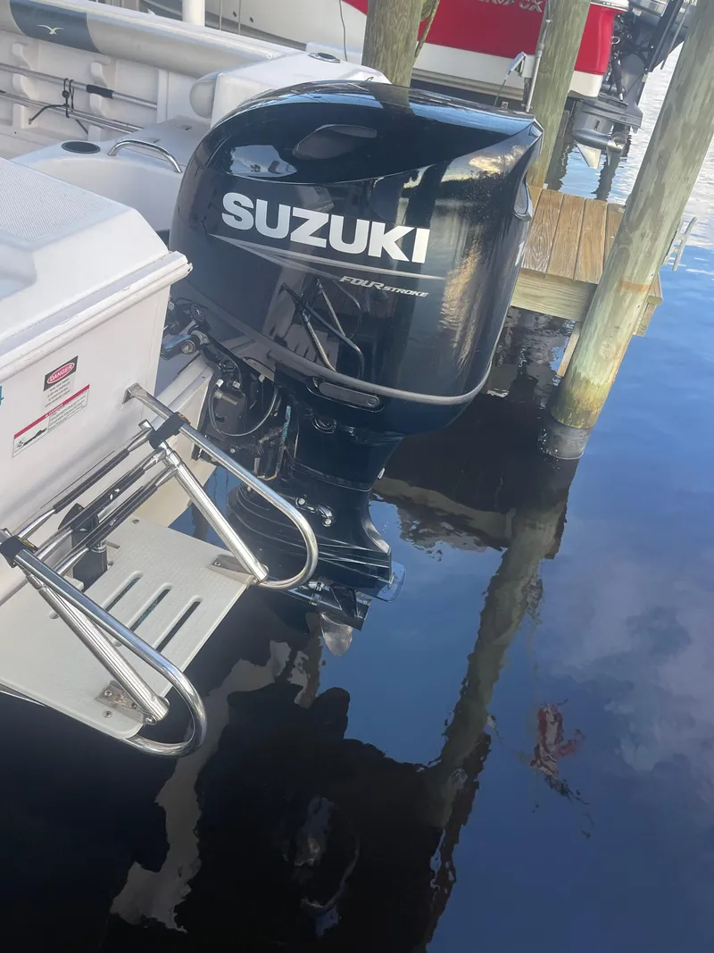 Slide: The Image of 2006 Pro-Line 21 Sport boat with Suzuki outboard motor docked on calm water. - 5