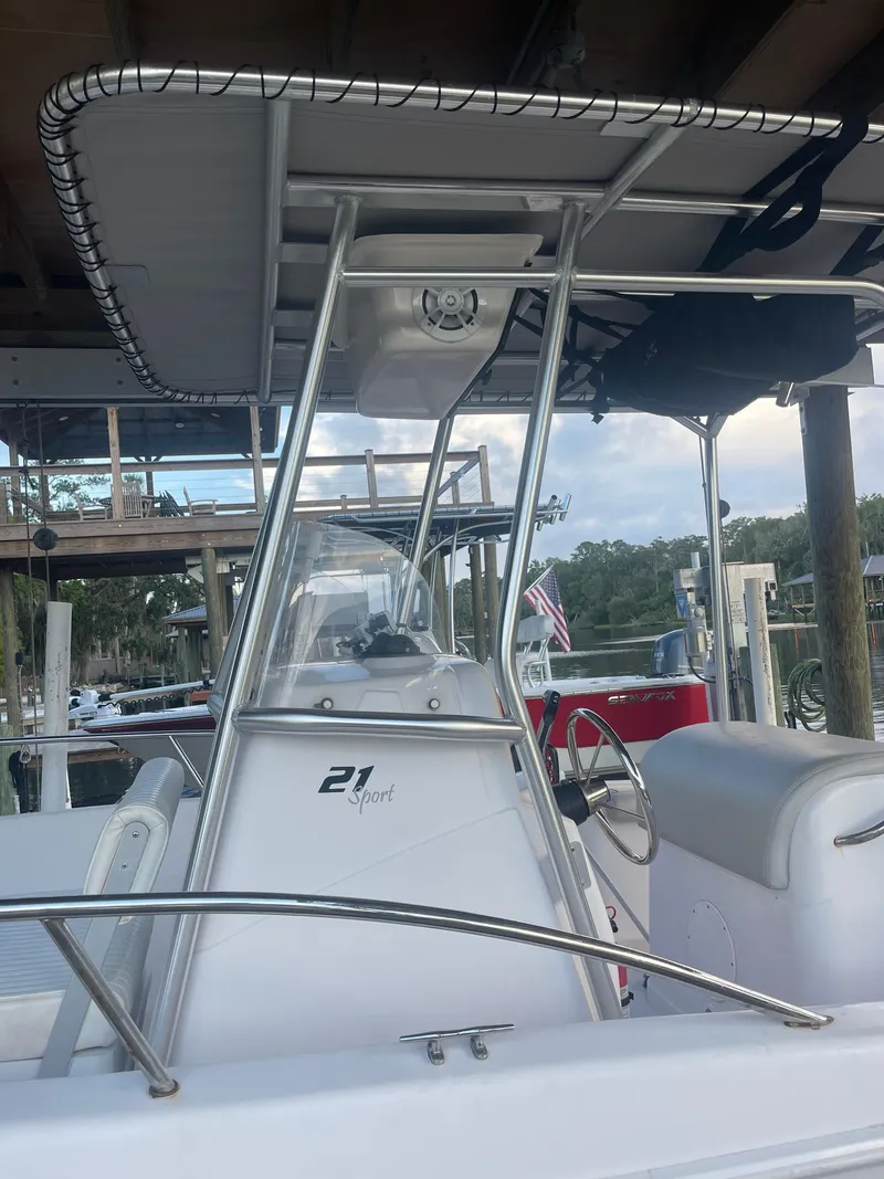 Slide: The Image of 2006 Pro-Line 21 Sport boat with T-top and console, docked near wooden pier. - 6