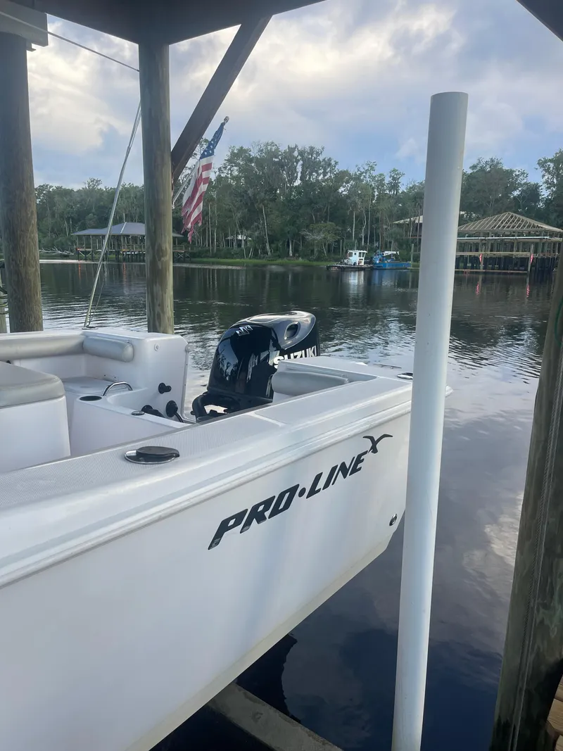 Slide: The Image of 2006 Pro-Line 21 Sport boat docked by a serene lake with trees in the background. - 7