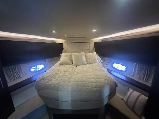 Slide: The Image of Luxurious cabin interior of 2017 Regal 53 Sport Coupe with cozy bed and ambient lighting. - 13