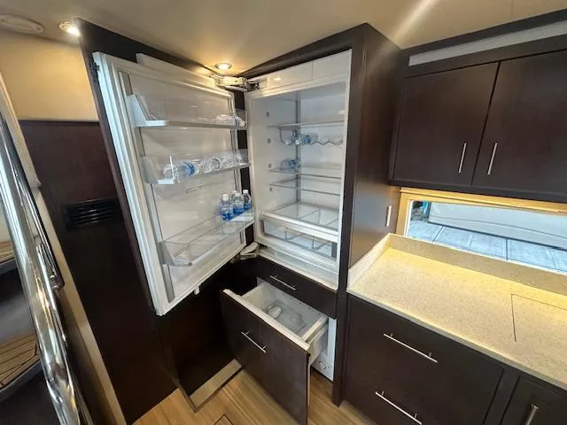 Slide: The Image of Luxurious kitchen interior of 2017 Regal 53 Sport Coupe with open fridge and modern cabinetry. - 16