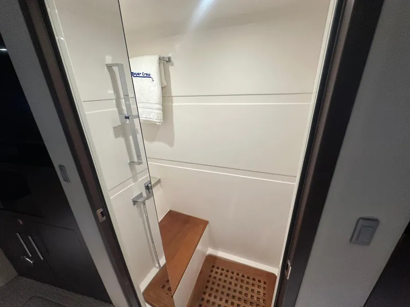 Slide: The Image of Shower area in 2017 Regal 53 Sport Coupe with wooden bench and towel rack. - 25