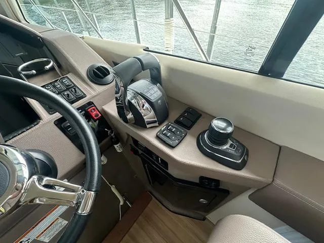 Slide: The Image of 2017 Regal 53 Sport Coupe helm with controls and steering wheel, docked by water. - 33