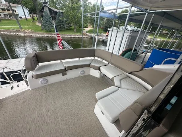 Slide: The Image of 2017 Regal 53 Sport Coupe boat with spacious outdoor seating area by a lakeside dock. - 37