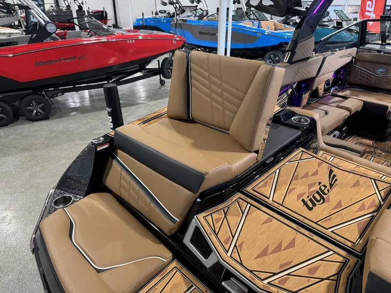 Slide: The Image of 2025 Tigé ULTRE 23ZX boat interior with tan seating and stylish design in showroom. - 14