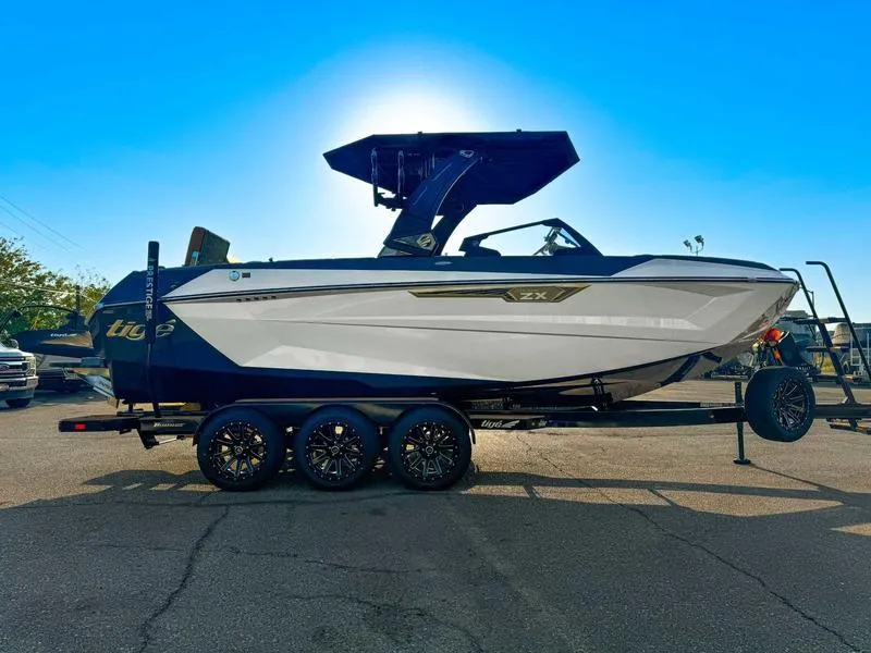 Slide: The Image of 2025 Tigé ULTRE 23ZX boat on trailer, sleek design, sunny day. - 4