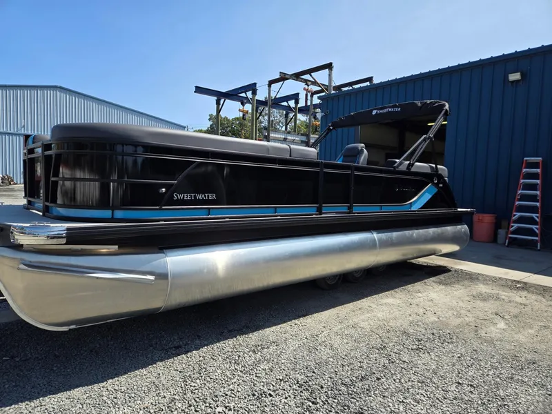 Slide: The Image of 2025 Godfrey Sweetwater 2486 SB pontoon boat parked outdoors. - 1