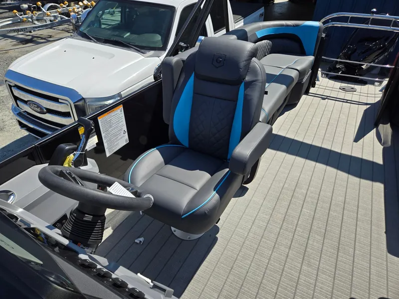 Slide: The Image of 2025 Godfrey Sweetwater 2486 SB boat interior with plush seating and steering wheel. - 15