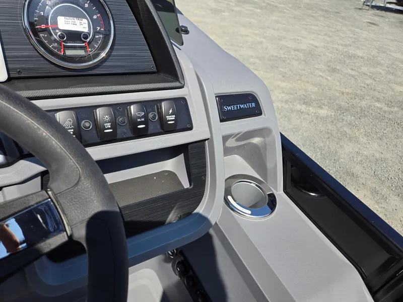 Slide: The Image of Dashboard of 2025 Godfrey Sweetwater 2486 SB boat with controls and cup holder. - 19