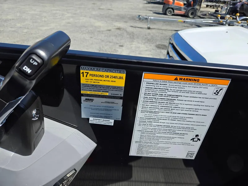 Slide: The Image of Capacity and warning labels on 2025 Godfrey Sweetwater 2486 SB boat dashboard. - 21