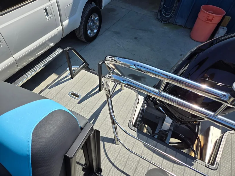 Slide: The Image of 2025 Godfrey Sweetwater 2486 SB boat deck with chrome railings and blue seating. - 27