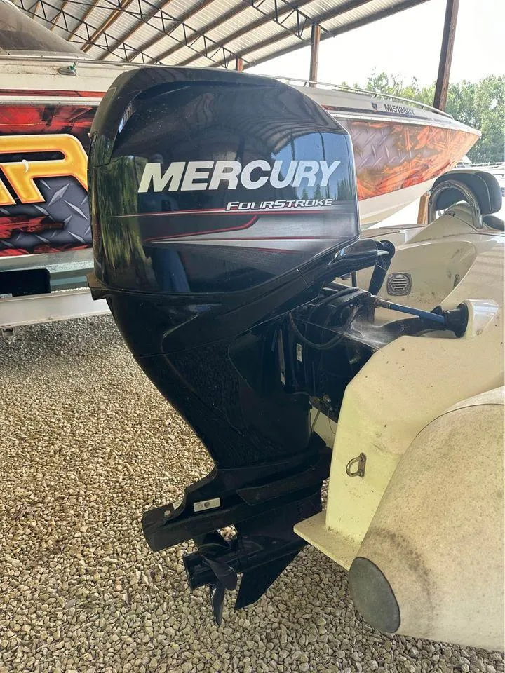 Slide: The Image of Mercury FourStroke outboard motor on a 2021 Zodiac 440DL boat, parked on gravel. - 8