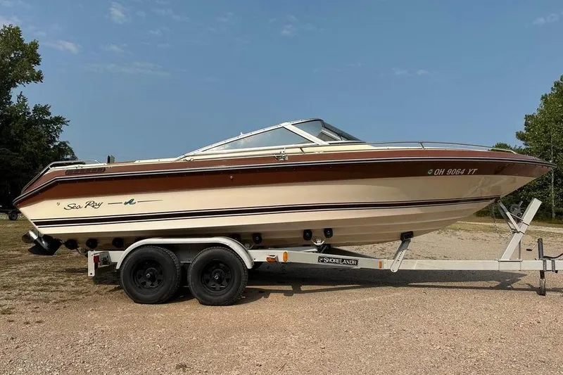 The Image of 1987 Sea Ray Sorrento 21 boat on trailer, parked outdoors. - 1