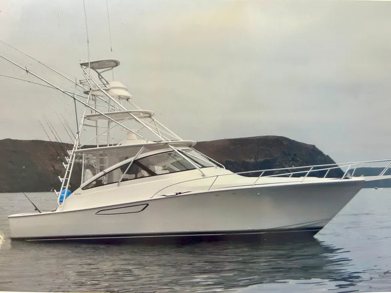 Slide: The Image of 2012 Viking 42 Open yacht on calm water with coastal backdrop. - 28