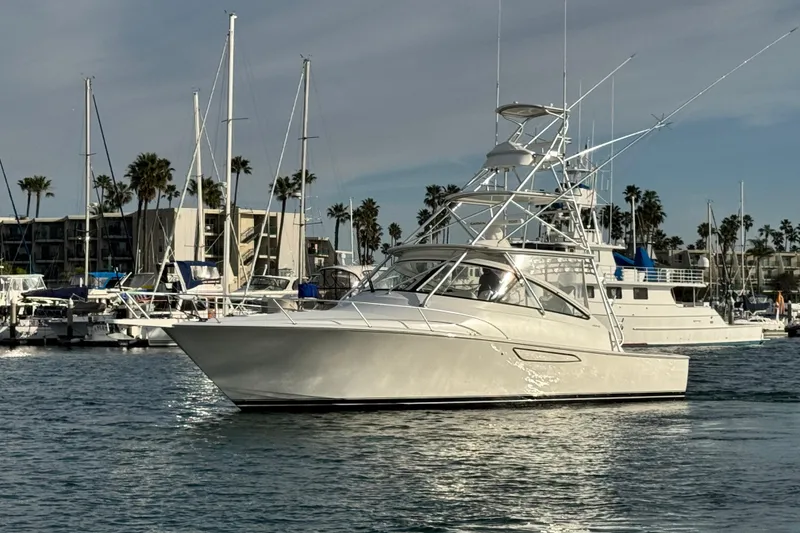 Slide: The Image of 2012 Viking 42 Open yacht docked in a marina with palm trees and boats. - 5