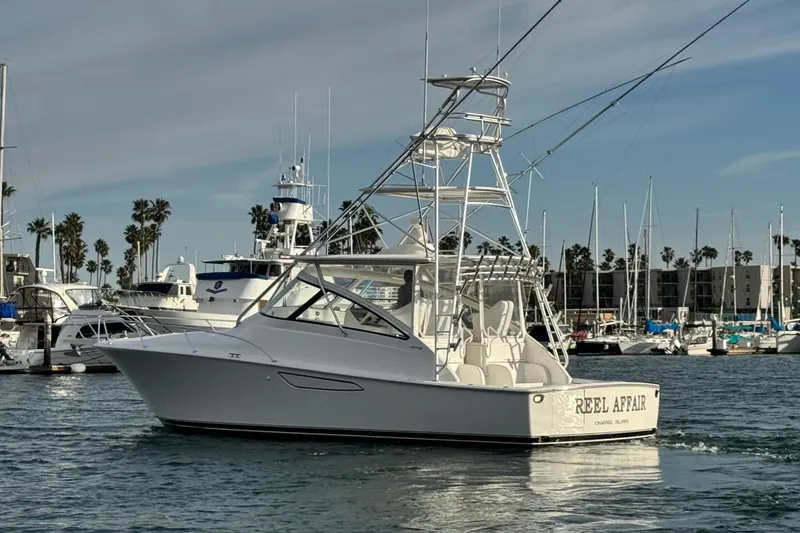 Slide: The Image of 2012 Viking 42 Open yacht in marina, surrounded by palm trees and other boats. - 6