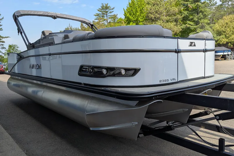 Slide: The Image of 2025 Avalon Catalina Versatile Rear Lounger pontoon boat on trailer, parked outdoors. - 4