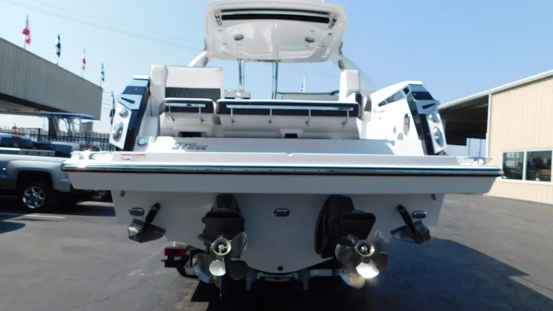 Slide: The Image of 2018 Monterey 378 SE boat rear view with dual propellers in a marina setting. - 21
