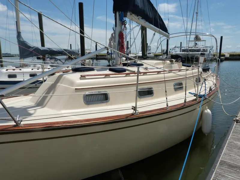 Slide: The Image of 1991 Island Packet 29 sailboat docked at marina, featuring classic design and beige hull. - 10