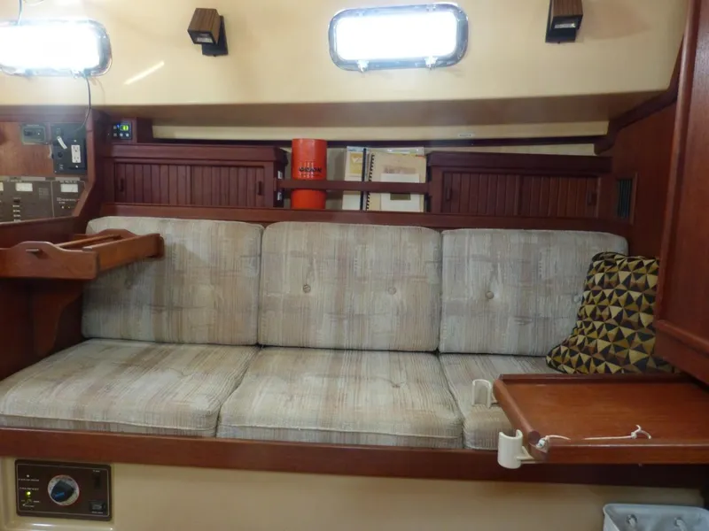Slide: The Image of Interior of 1991 Island Packet 29 sailboat with cushioned seating and wooden accents. - 3
