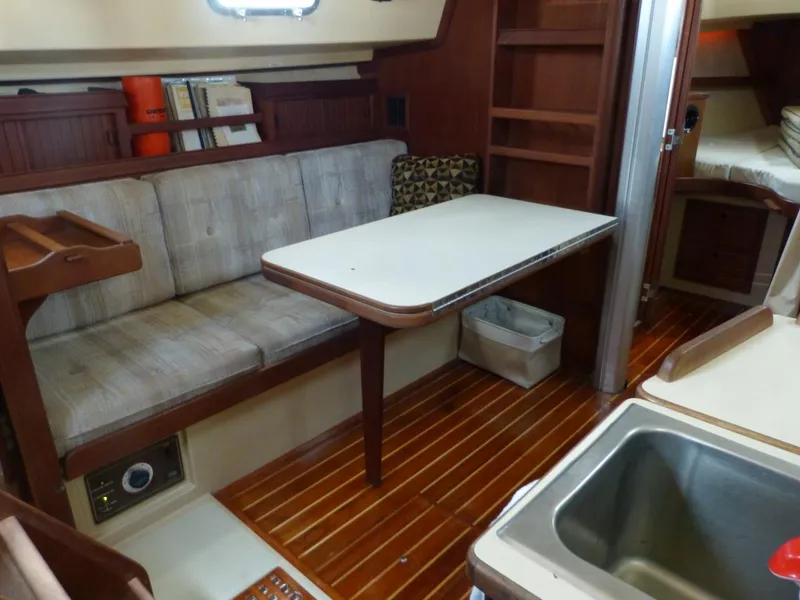 Slide: The Image of 1991 Island Packet 29 interior with seating, table, and wooden flooring. - 4