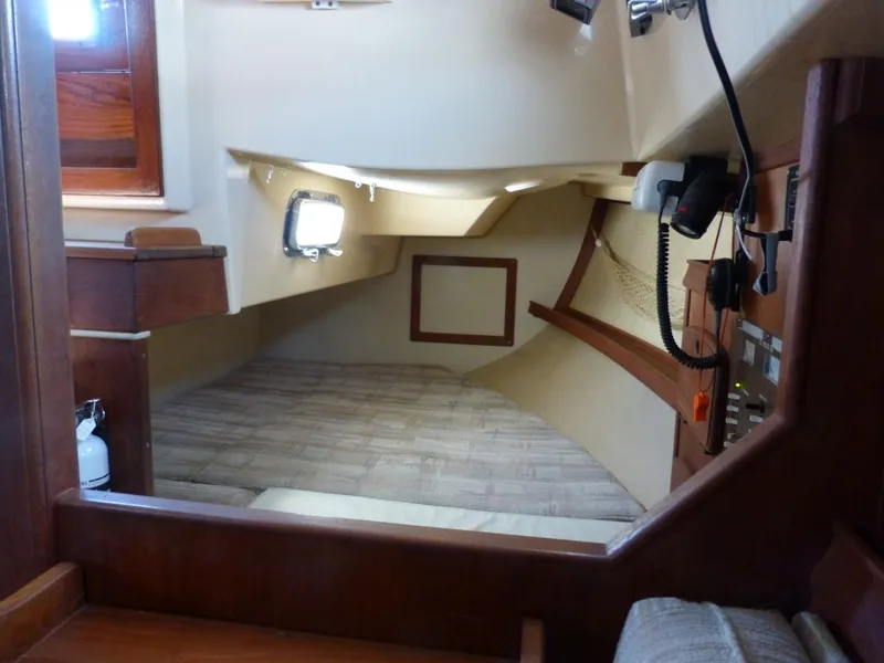 Slide: The Image of Interior cabin of 1991 Island Packet 29 sailboat, featuring wood accents and a cozy berth. - 6