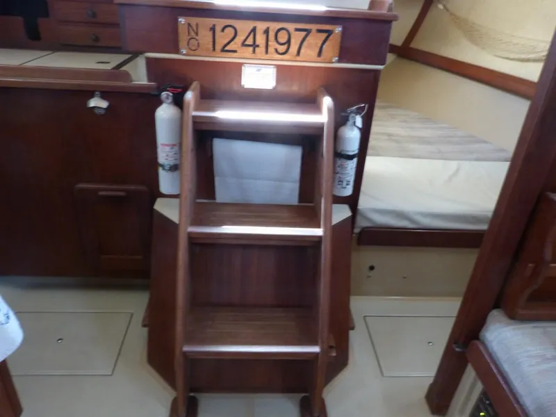 Slide: The Image of Interior of 1991 Island Packet 29 sailboat with wooden steps and fire extinguishers. - 7