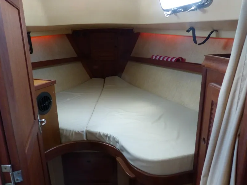 Slide: The Image of Cozy cabin interior of 1991 Island Packet 29 sailboat with V-berth and wooden accents. - 8