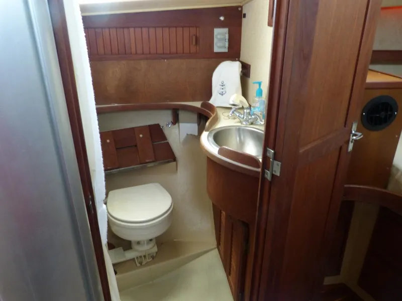 Slide: The Image of 1991 Island Packet 29 sailboat bathroom with wooden cabinetry and stainless steel sink. - 9