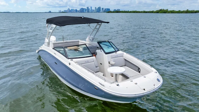 Slide: The Image of 2023 Sea Ray SDX 270 Outboard boat on water with city skyline in background. - 11