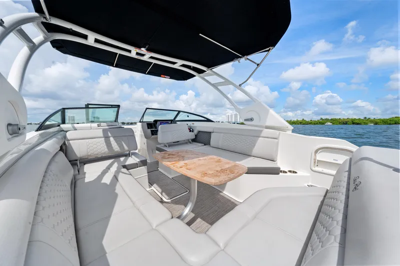 Slide: The Image of 2023 Sea Ray SDX 270 Outboard boat interior with seating and table, on a sunny day. - 21