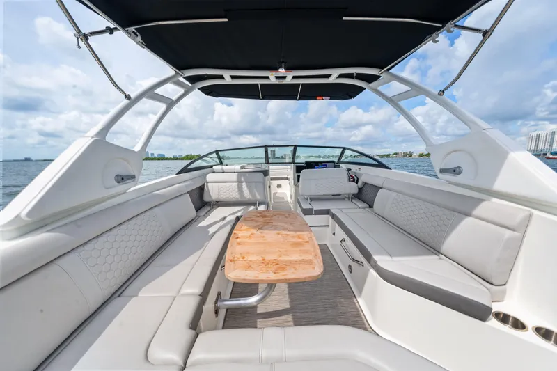 Slide: The Image of 2023 Sea Ray SDX 270 Outboard interior with spacious seating and wooden table. - 22