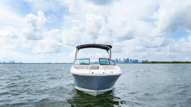 Slide: The Image of 2023 Sea Ray SDX 270 Outboard on open water with city skyline backdrop. - 3