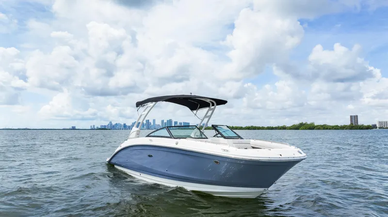 Slide: The Image of 2023 Sea Ray SDX 270 Outboard boat on open water with city skyline. - 4