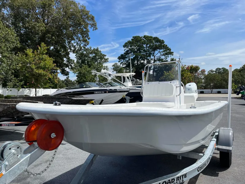 Slide: The Image of 2025 Coastal Skiff 171 boat on trailer, parked outdoors under a clear sky. - 1