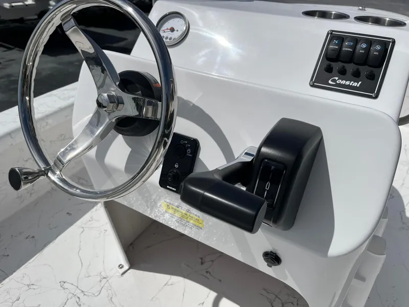 Slide: The Image of 2025 Coastal Skiff 171 boat console with steering wheel and controls. - 10