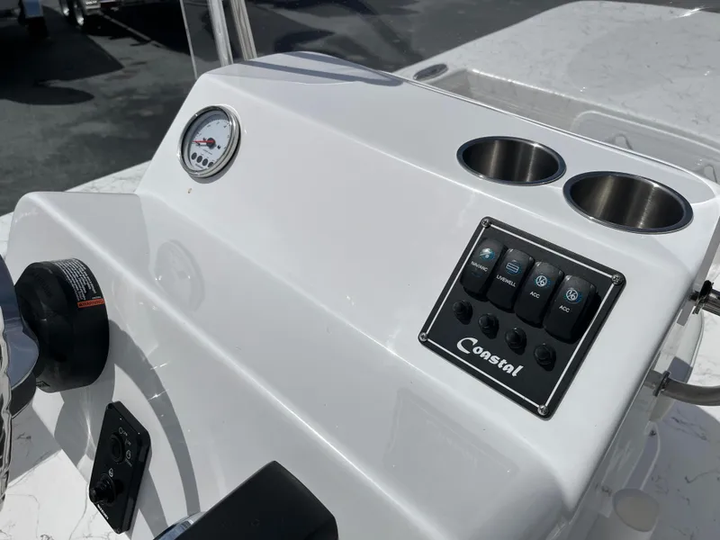 Slide: The Image of 2025 Coastal Skiff 171 boat console with gauges and cup holders. - 11