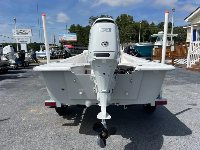 Slide: The Image of 2025 Coastal Skiff 171 boat with outboard motor, displayed outdoors on a sunny day. - 4