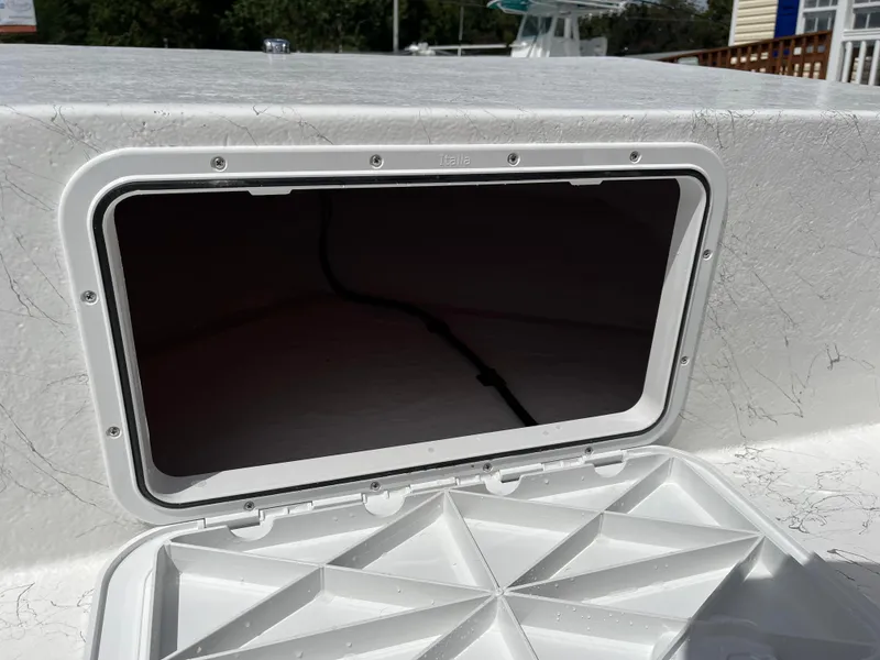 Slide: The Image of Coastal Skiff 171 boat storage compartment, 2025 model, open lid view. - 8