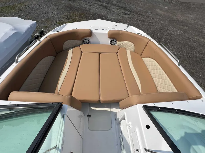 Slide: The Image of 2025 NauticStar 223 DC boat interior with tan cushioned seating and white accents. - 8