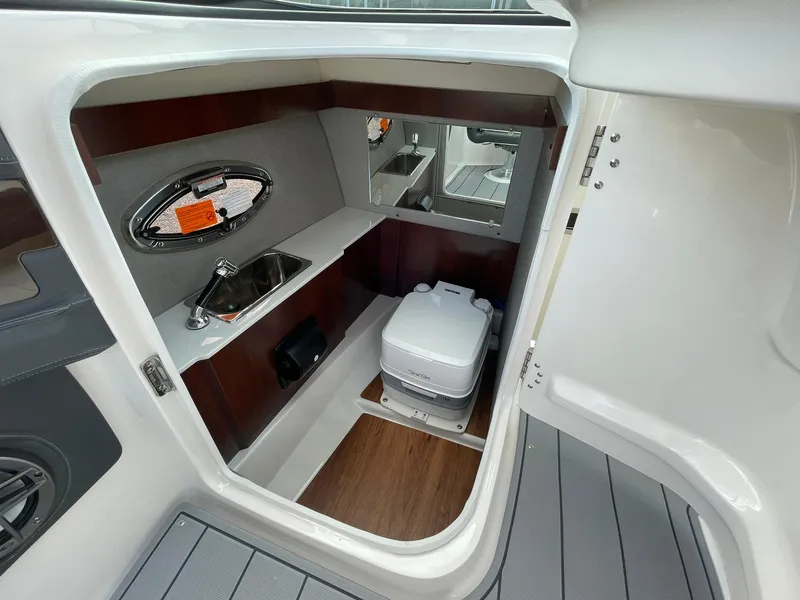 Slide: The Image of 2025 Chaparral 270 OSX boat interior with sink and portable toilet. - 23
