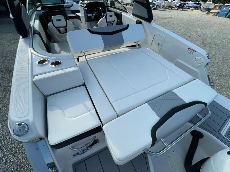 Slide: The Image of 2025 Chaparral 270 OSX boat interior with white seating and cup holders. - 45