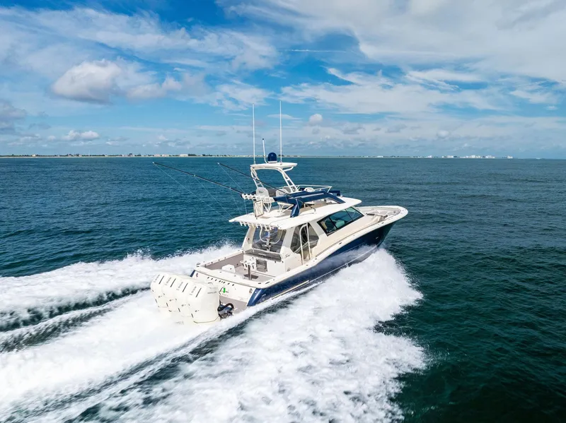 Slide: The Image of 2022 Scout LXF boat cruising on open ocean under blue sky. - 1